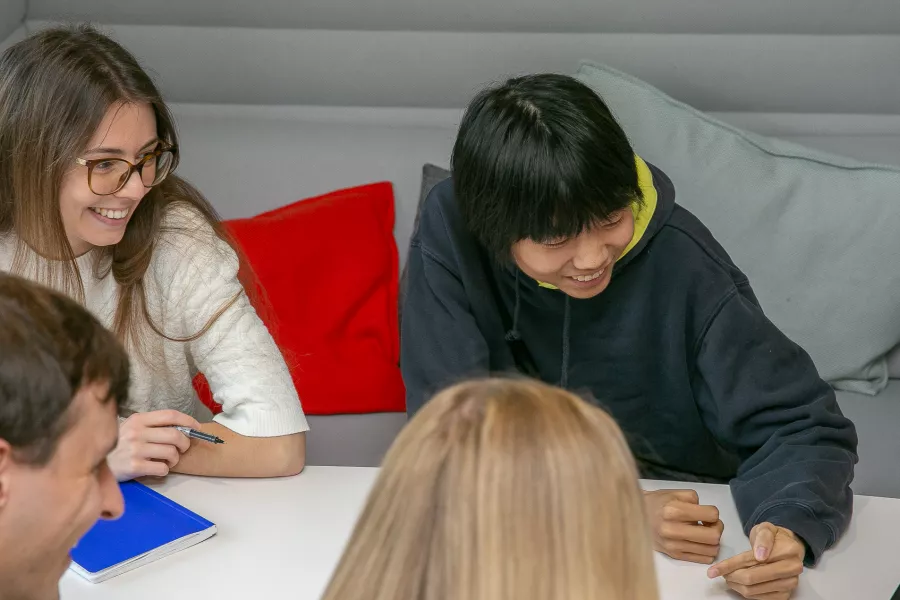 Group of smiling students around laptop